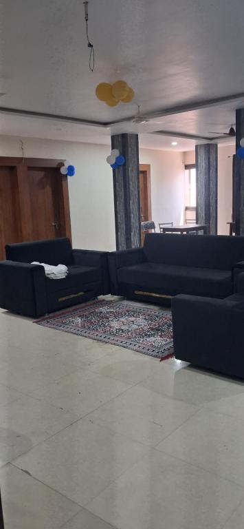 a living room with couches and a rug at Tansen Guest House in Gwalior