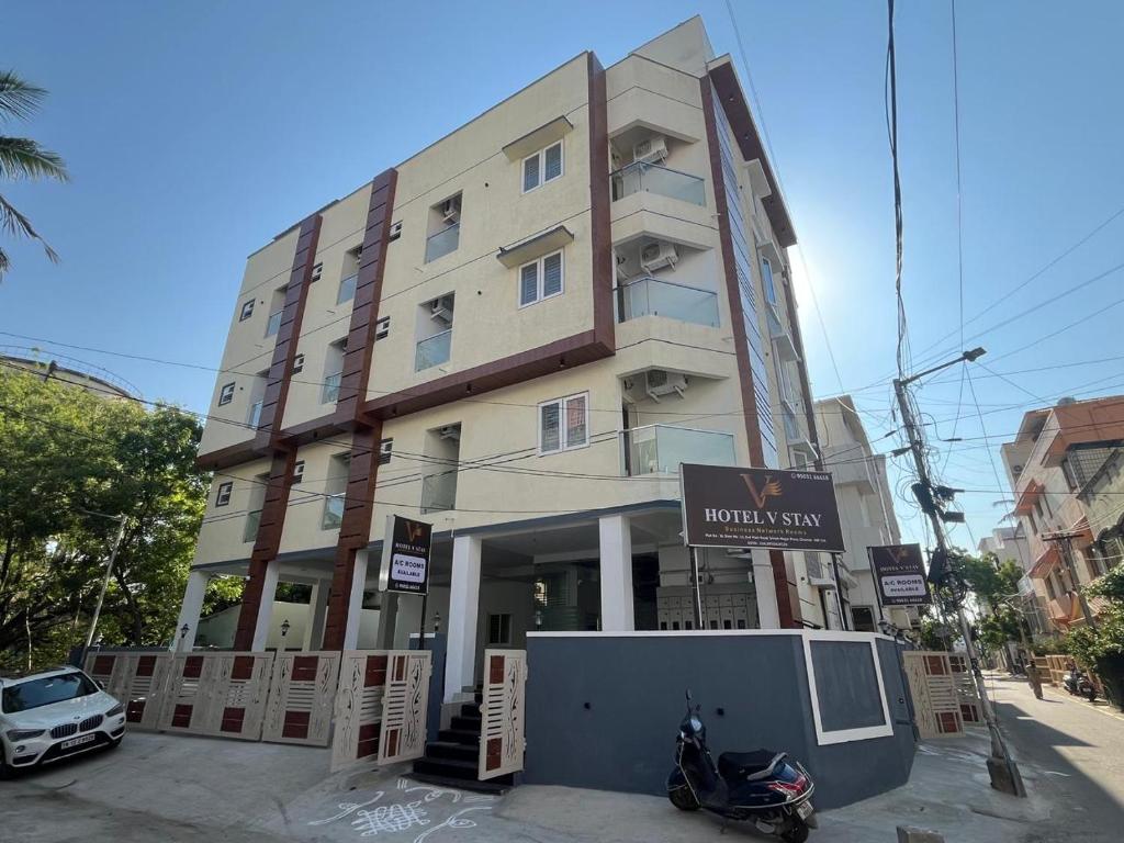 a building with a motorcycle parked in front of it at Hotel V Stay in Chennai