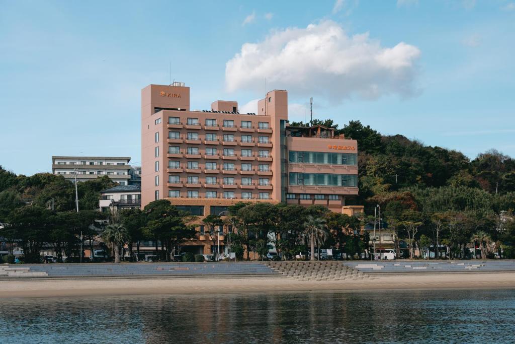 a large building on a hill next to a beach at Ryugu Hotel in Nishio
