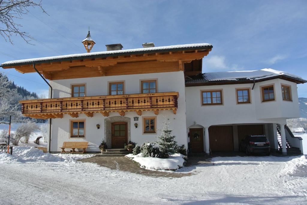 une maison avec un toit en bois dans la neige dans l'établissement Kugellehen, à Radstadt