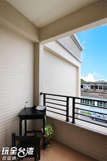 balcón con mesa y vistas a un tren en 鐵花國小民宿, en Taitung