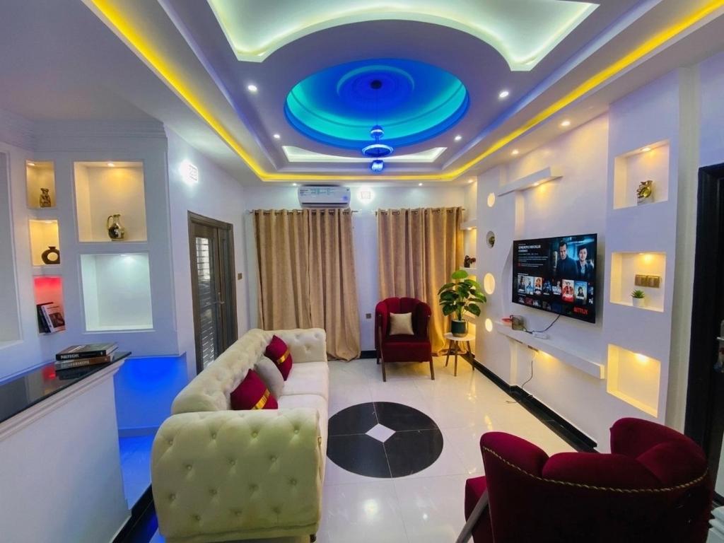 a living room with a couch and a tv at Gustavó Premium Apartment in Benin City