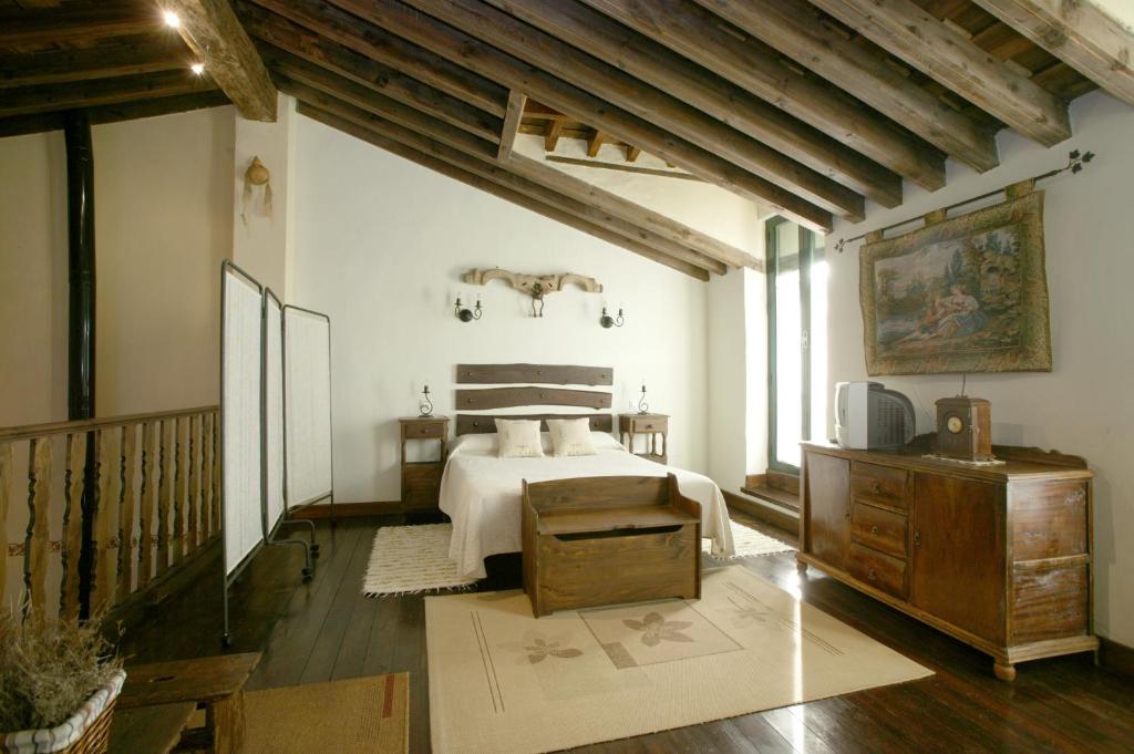 a bedroom with a bed in a room with wooden ceilings at La Rinconera in Mingorría