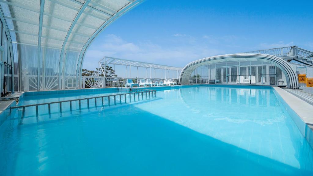 a large swimming pool in a building with a building at Ganghwa imspa Pension in Incheon