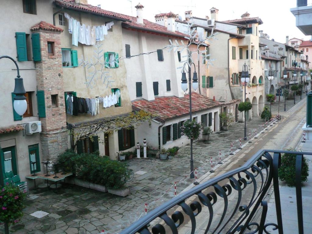 a city street with clothes hanging from buildings at Posta Vecchia in Grado
