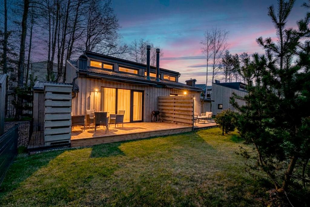 a small house with a deck in a yard at Sunset House in Palanga