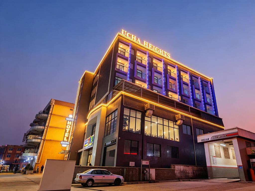 a building with a car parked in front of it at Ucha Hotel & Suites in Kampala