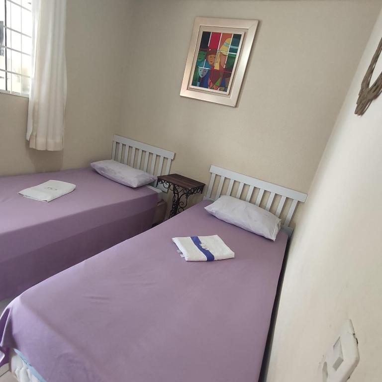 two beds sitting next to each other in a room at Pousada Sonho in Apucarana