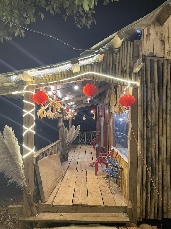 a wooden deck with red lanterns on it at night at Homestay Vườn Cam in Kon Von Kla
