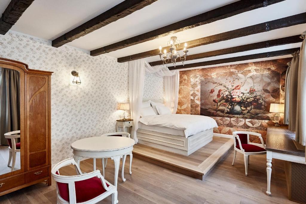 a bedroom with a bed and a table and chairs at Maison Bistro & Hotel in Budapest