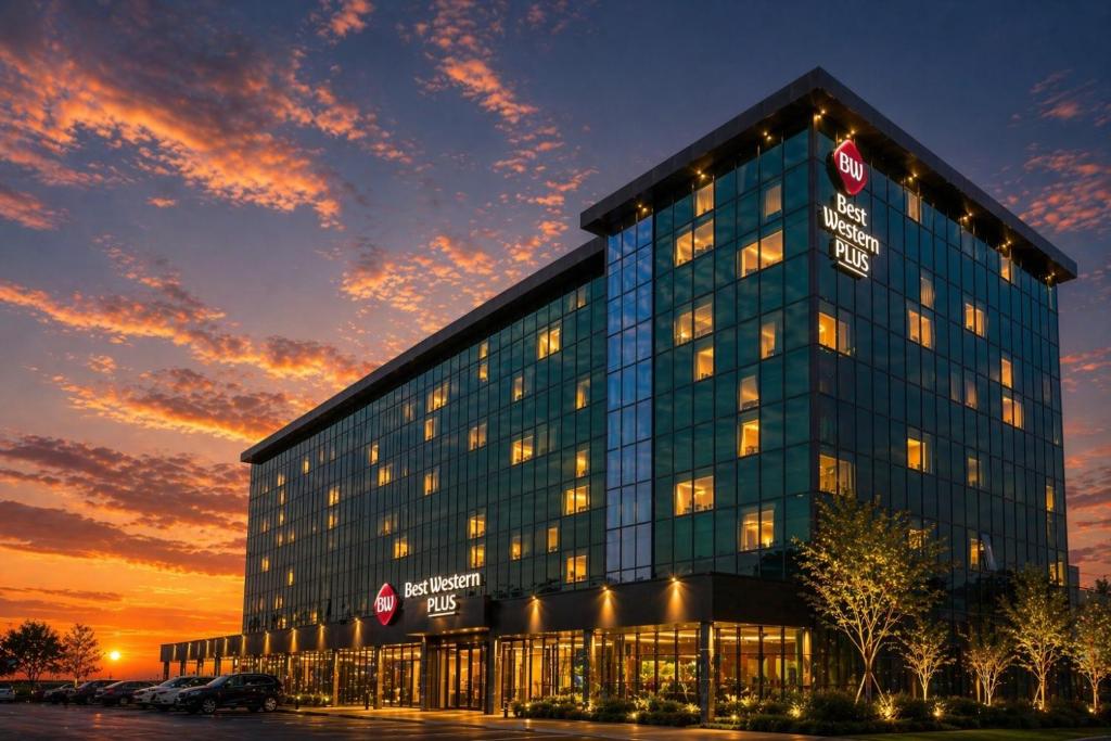 a large glass building with a sunset in the background at Best Western Plus The Met Tirana Hotel in Tirana