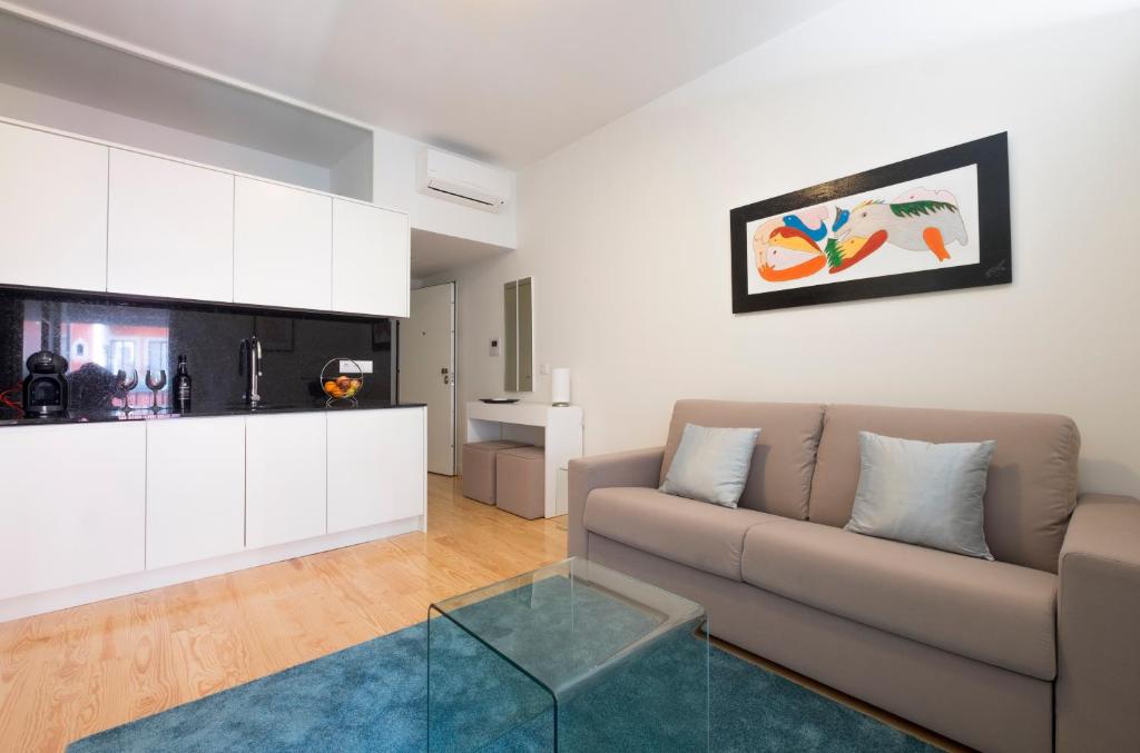 uma sala de estar com um sofá e uma mesa de vidro em Home At Porto - Aliados Apartments em Porto