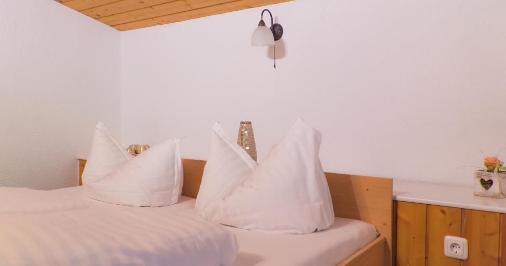 ein Schlafzimmer mit weißen Kissen auf einem Bett in der Unterkunft Alpenresorts in Jerzens