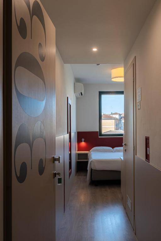 a room with a bedroom with a bed and a window at Hotel Porta Palio in Verona