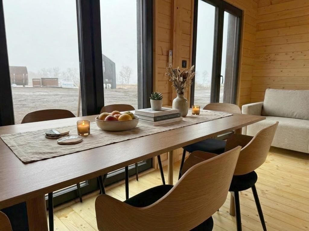 a dining room table with a bowl of fruit and candles at Domki Lubikowo in Przytoczna 