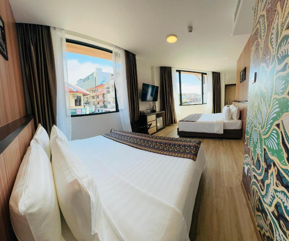 a hotel room with a large bed and a window at Sri Gaya Hotel in Kota Kinabalu