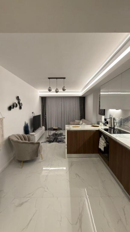 a large white kitchen with a couch and a table at Grand Saphire Resort c blok in Aradhippou