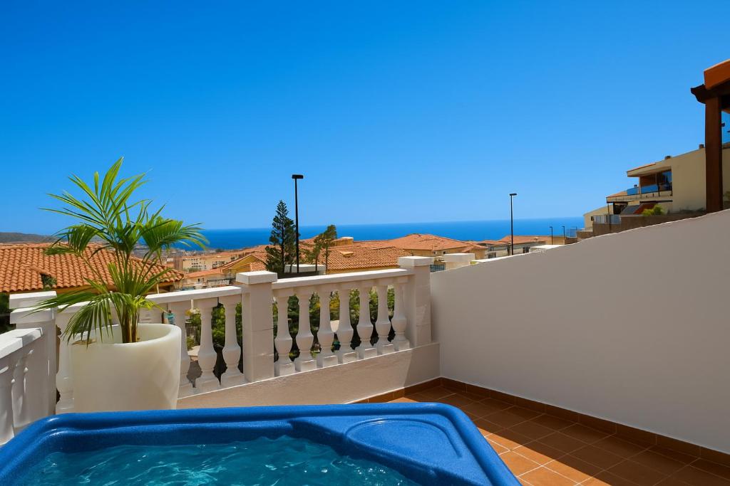 a hot tub on a balcony with a view of the ocean at Sea Breeze Arguineguin in Mogán