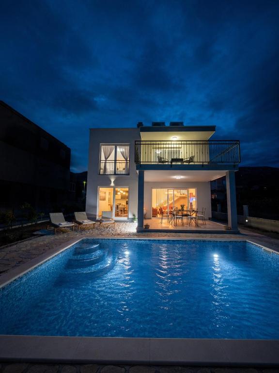 a house with a swimming pool at night at Villa Fidelissima in Kaštela