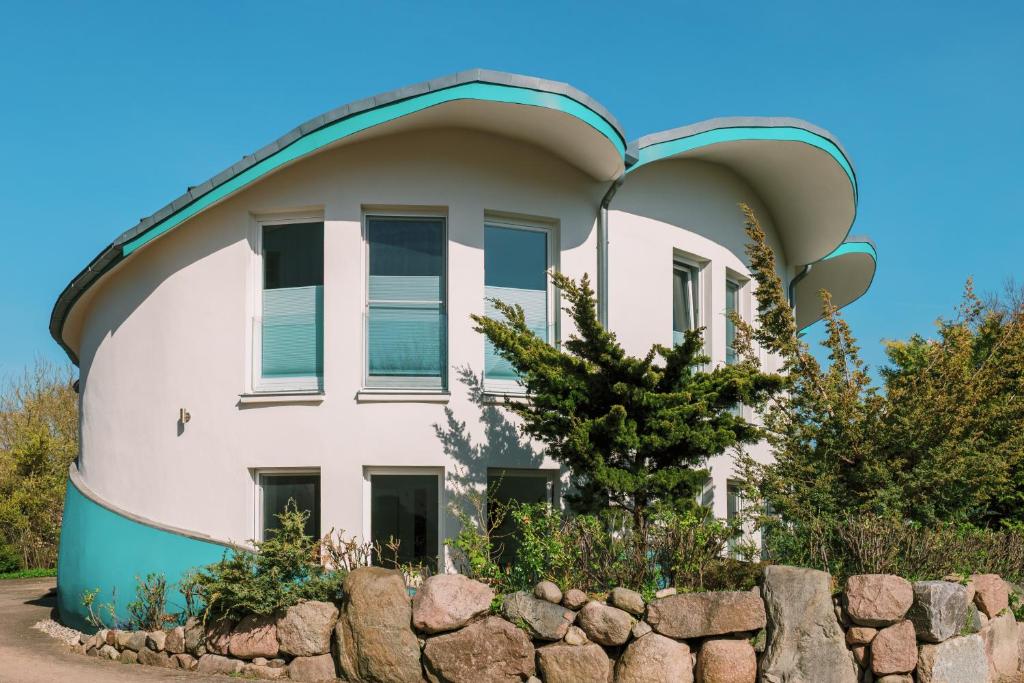 an orb shaped house with a stone wall at Muschel 4 in Ahrenshoop