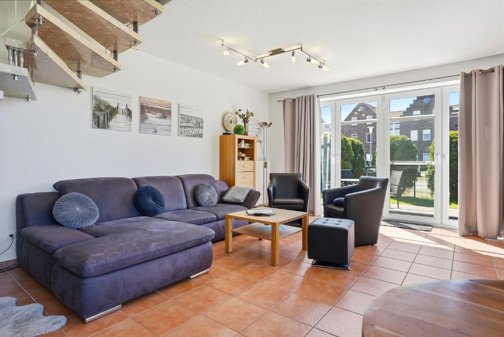 a living room with a couch and a table at Möwenblick in Norddeich