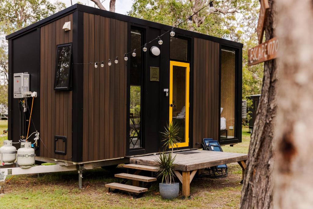 a tiny house on a trailer with a bench at Bushwalk Escape 1770 in Agnes Water