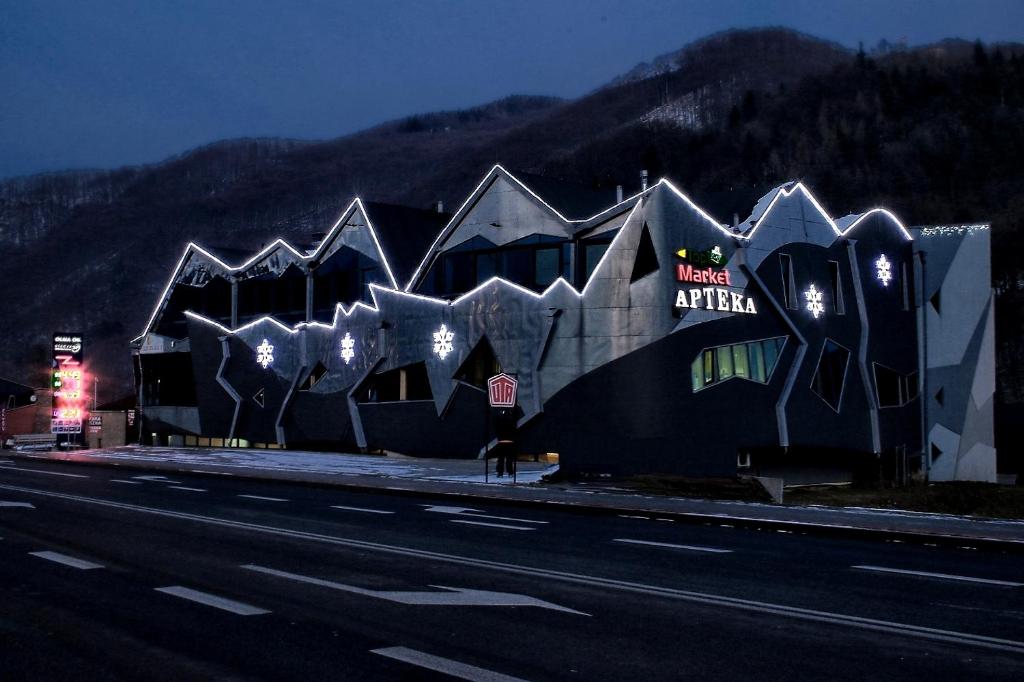 a building with lights on it next to a highway at Zajazd Pod Zamkiem Rytro in Rytro