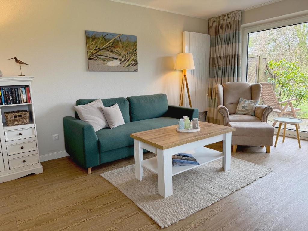 a living room with a green couch and a table at Wohnung Wiesenblick Whg 1 in Böhl