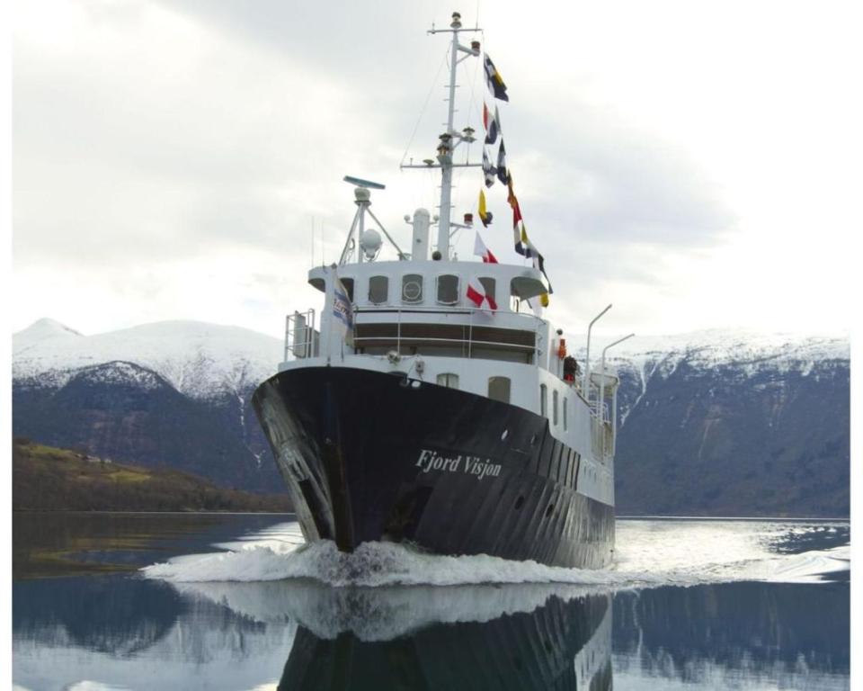 a large boat in a body of water at Lofoten Cruise & Hotel in Svolvær