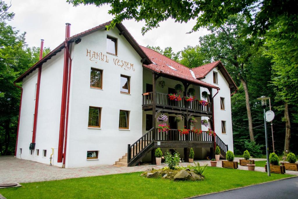 a white building with flowers on the balcony at Hanul Vestem in Sibiu