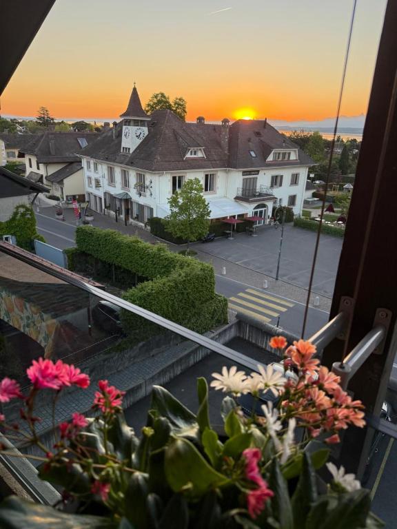 a view from a window of a building with a sunset at Auberge de Founex in Founex