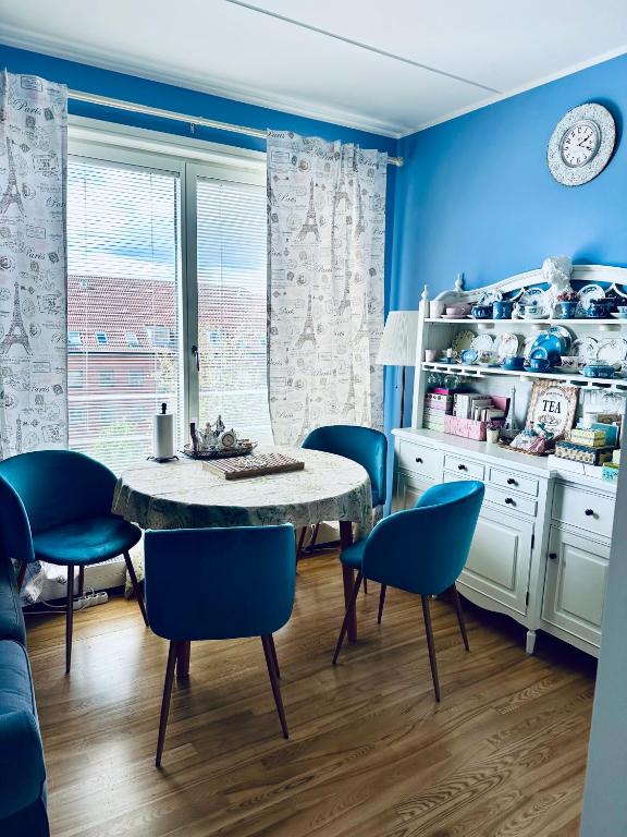 a dining room with blue walls and a table and chairs at Beach & City Fun plus Elevator & Free Parking in Hellerup