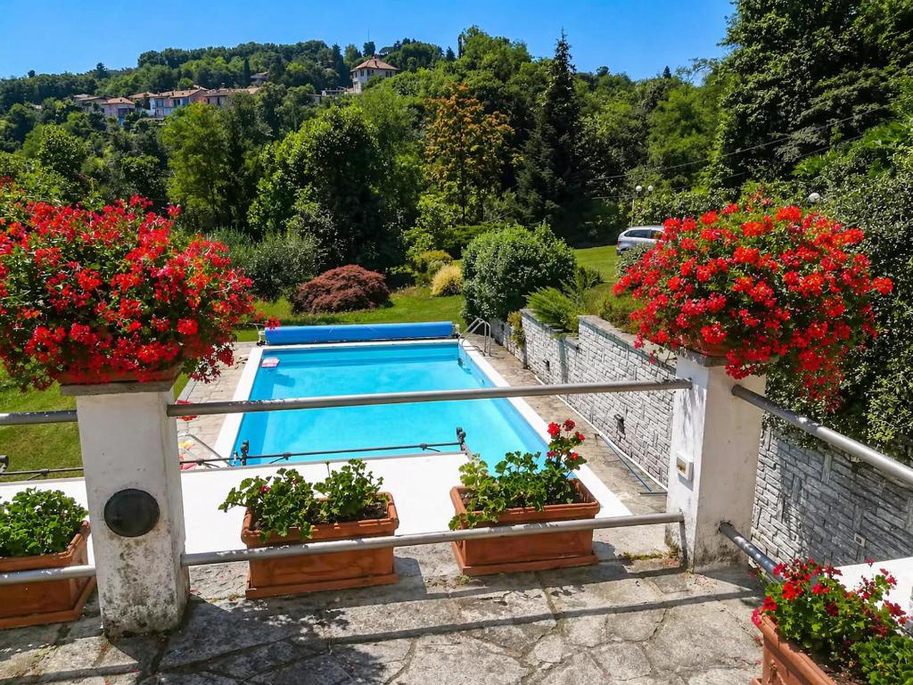 a swimming pool with flowers on a balcony at Villa Romilda in Arona