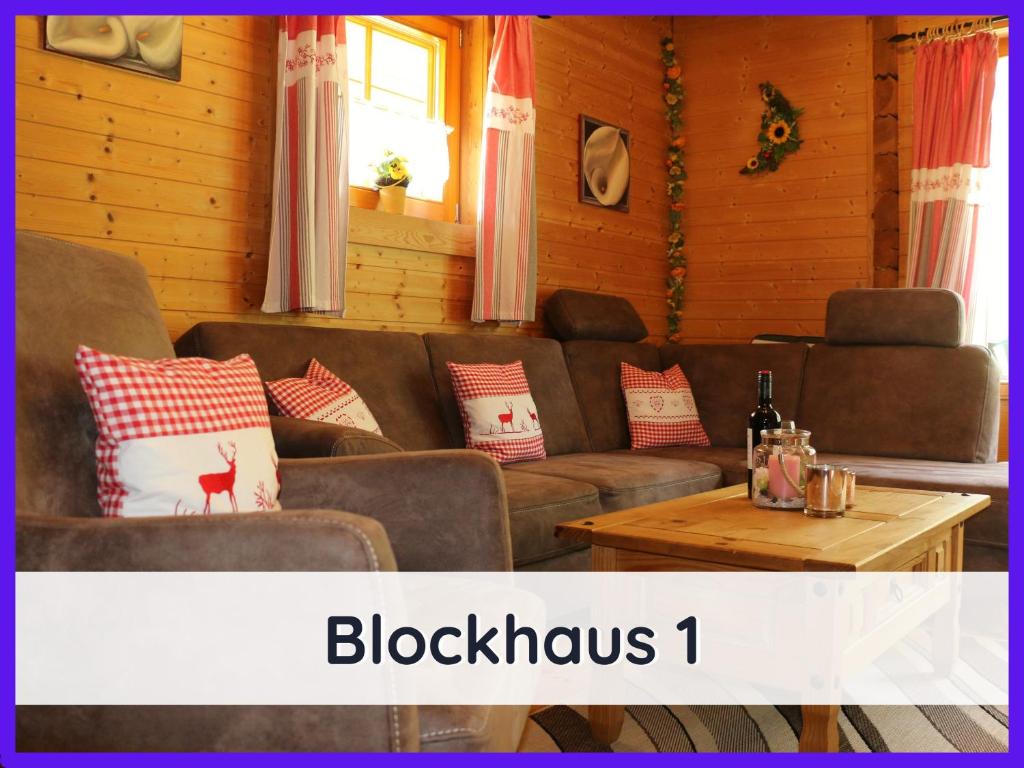 a living room with a couch and a table at Der Fuchsbau - 3 Blockhäuser in Bad Sachsa