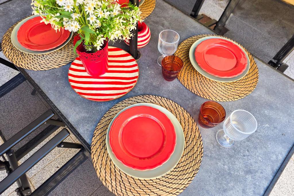 a table with red plates and hats and flowers at Patio House - 2 Bedroom flat in Porto