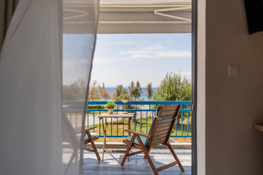 a patio with two chairs and a table on a balcony at Orion 2 in Neos Marmaras
