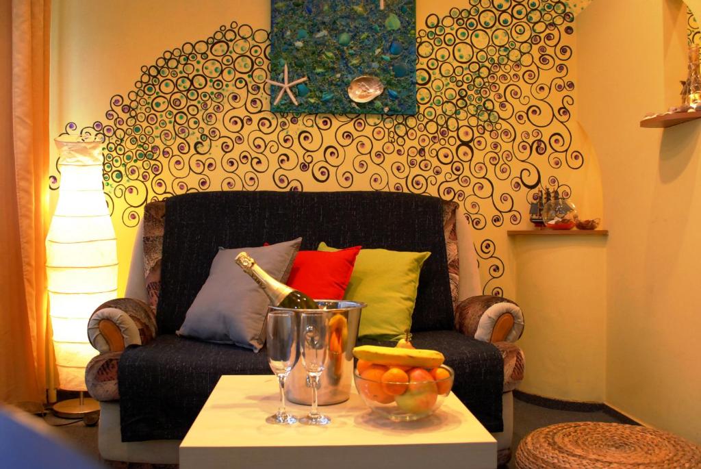 een woonkamer met een stoel en een tafel met een fruitschaal bij Sunny Old Town Apartments in Boekarest
