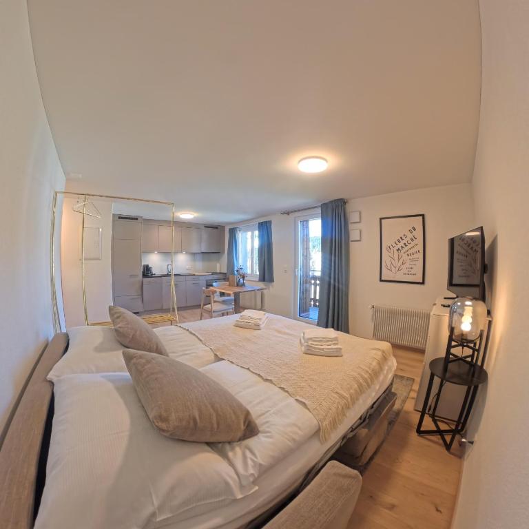 a bedroom with a large bed with pillows on it at Stylish Aurora Studio with Mountain Views Lenzerheide in Lenzerheide
