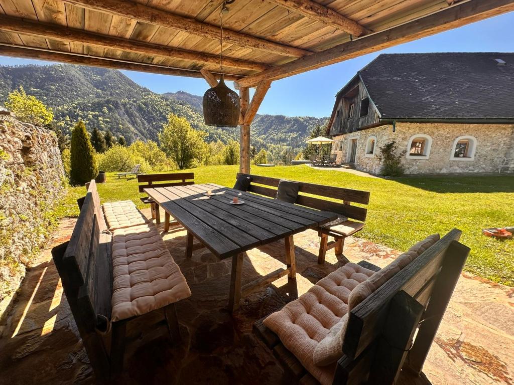 a wooden table and chairs on a patio at Obiralmhütte Mosgan in Bad Eisenkappel
