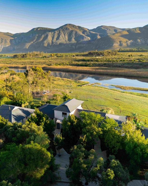 an aerial view of a house in a field with mountains at Springfontein River Lodge in Stanford