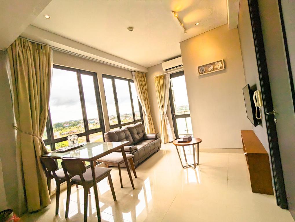 a living room with a couch and a table and chairs at Lovina 5-AA at One Residence in Batam Center