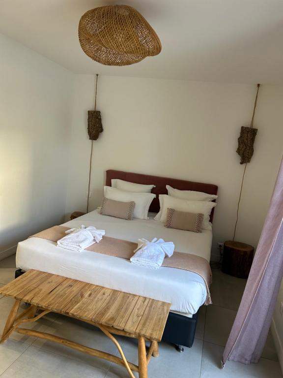 a bedroom with a bed and a table with towels on it at Chambres d’hôtes Casarena in Porto-Vecchio