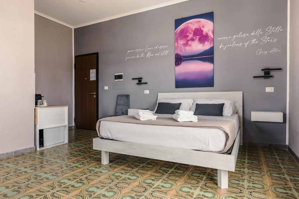 a bedroom with a large bed with a poster on the wall at Malù House in Fiumicino
