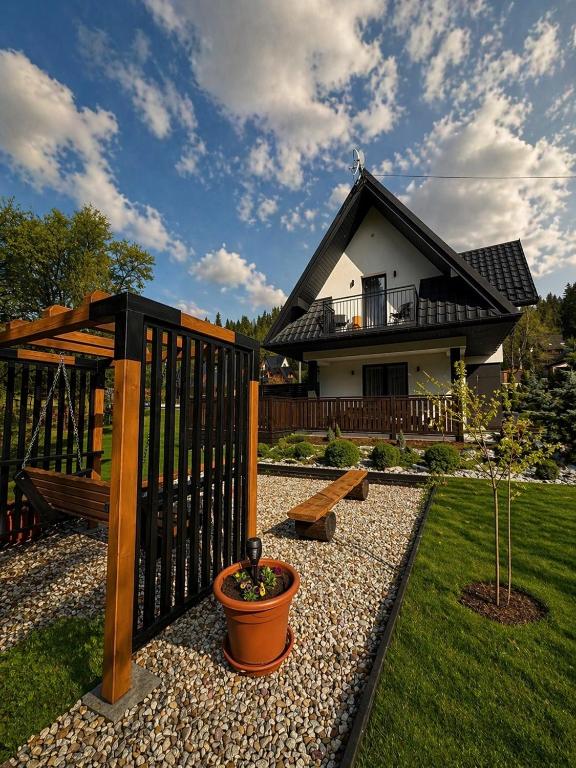 a house with a fence and a bench in a yard at Domek Sołtysówka Balia&Sauna in Gliczarów Górny