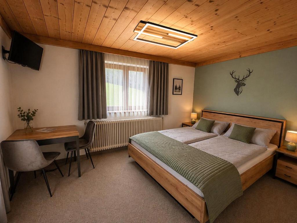a bedroom with a bed and a desk with a desk at Pension Sonneck in Pfarrwerfen