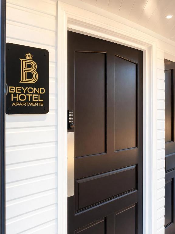 a door to a hotel with a sign on it at Beyond Hotel & Apartments in Burnley