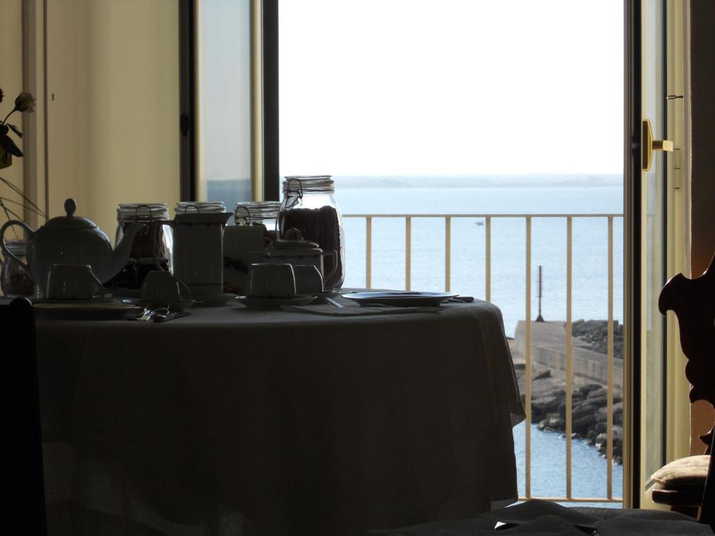 a table with jars on it with a view of the ocean at Palazzo De Tomasi B&B in Gallipoli