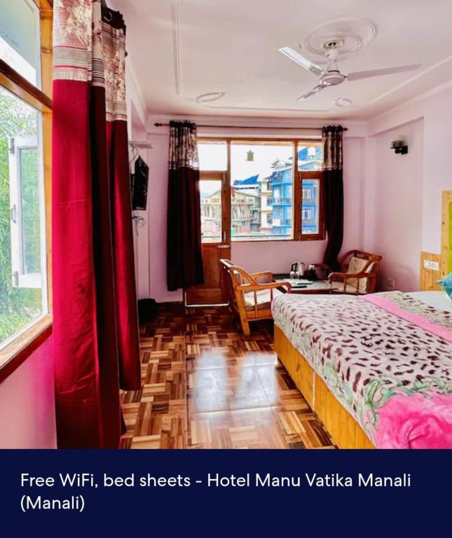a bedroom with red curtains and a bed and a table at Hotel Royal Selection in Manāli