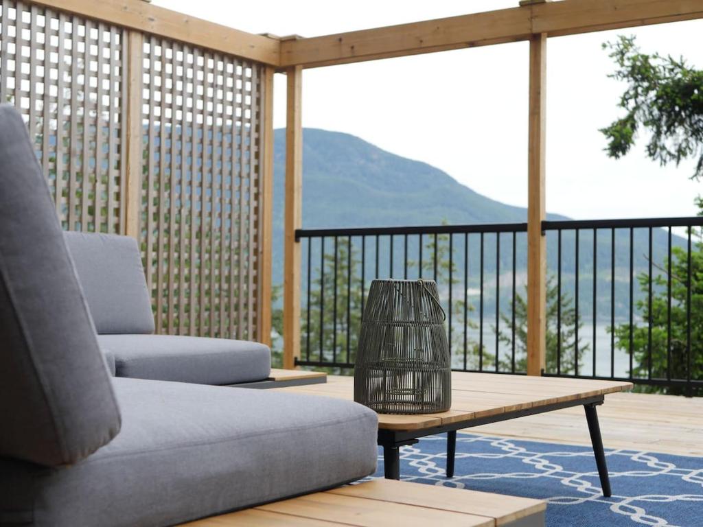 a porch with a couch and a coffee table on a balcony at Howe Sound View in Bowen Island