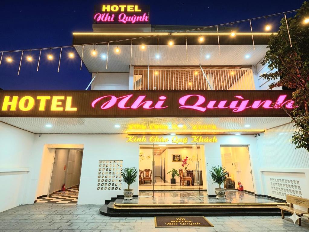 a hotel with a neon sign in front of it at Nhi Quỳnh La Gi Hotel in Lagi